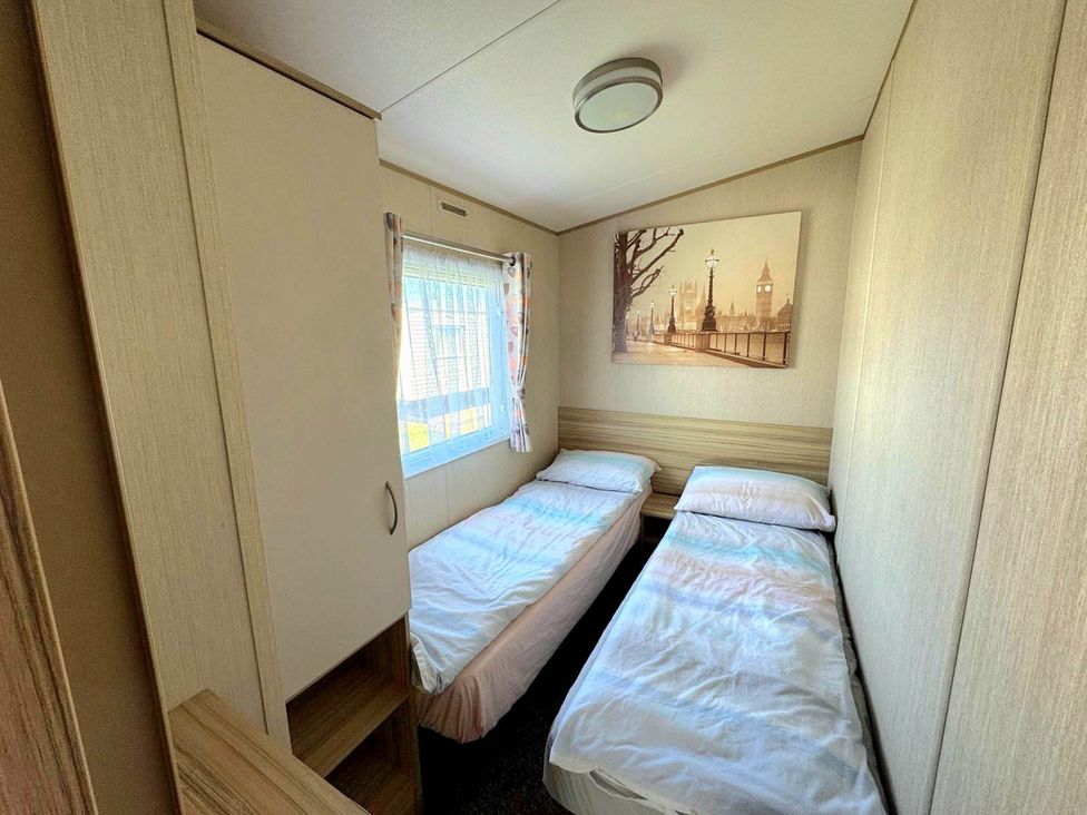 A bedroom with two single beds and a window at St Osyth- Sleeps8-freeparking-wifi-holidaypark Clacton-On-Sea