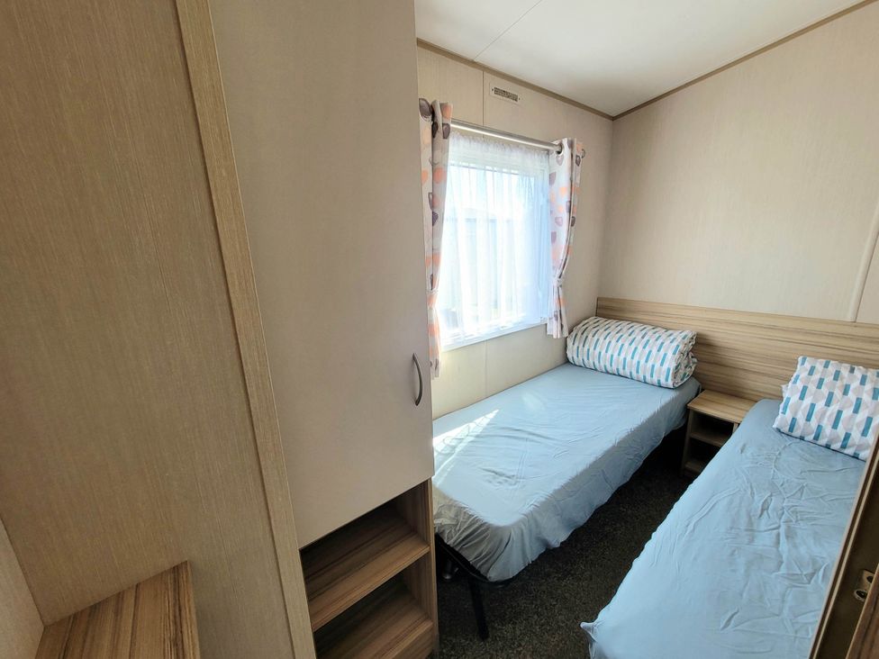 A bedroom with two beds and a wardrobe at St Osyth- Sleeps8-freeparking-wifi-holidaypark Clacton-On-Sea