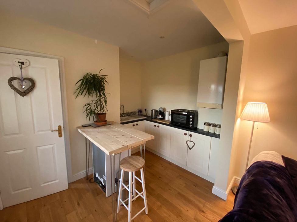 A kitchen with a table and bar stool at Cosy stable conversion between Sheffield & Leeds Pontefract