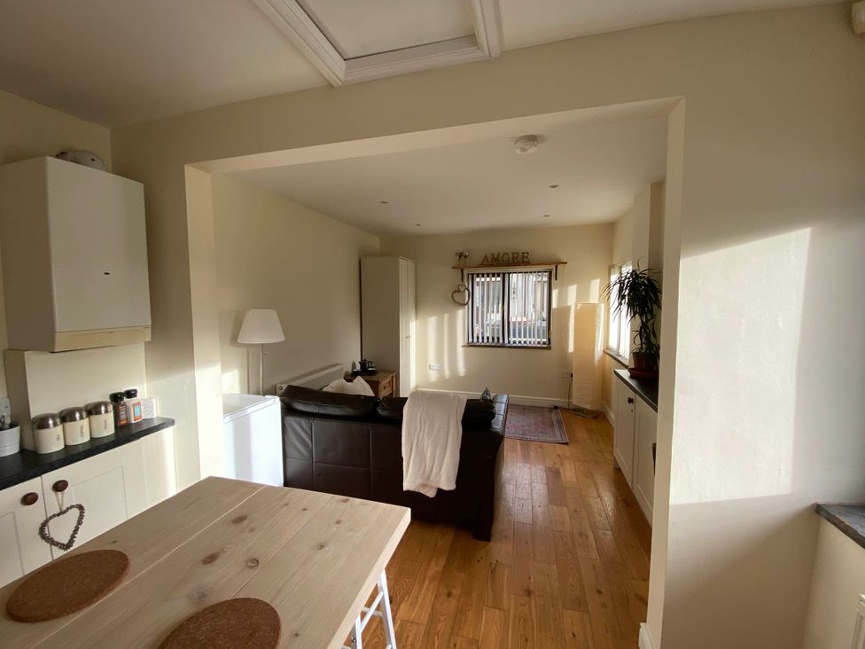 A kitchen with a sofa and a dining table at Cosy stable conversion between Sheffield & Leeds in Pontefract