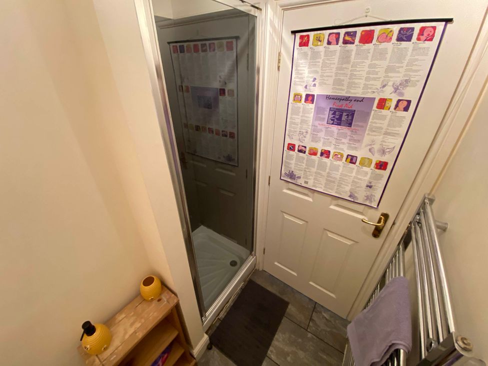 A bathroom with a shower, door, and towel rail at Cosy stable conversion between Sheffield & Leeds in Pontefract