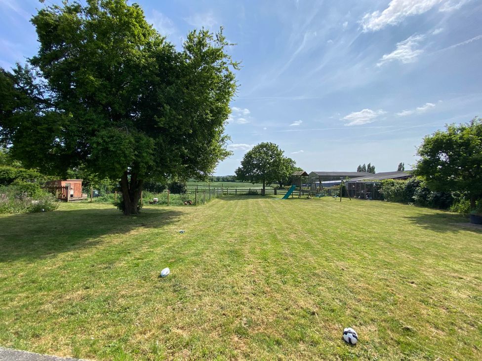 An outdoor area with grass and trees at Cosy stable conversion between Sheffield & Leeds in Pontefract