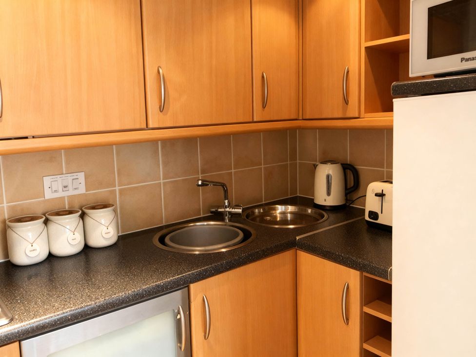 A kitchen with sink, kettle, toaster, and cabinets at 1 Bed House - Central, Free Parking, Wifi in Stirling