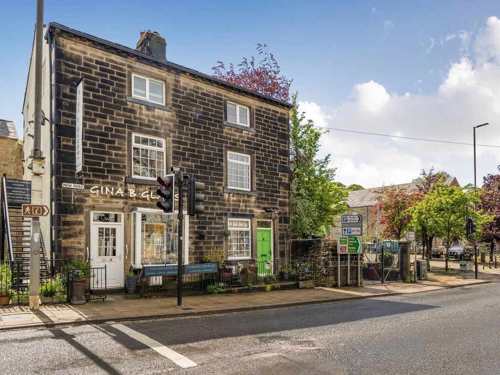 A stone building with a shop front and street views in Hebden Bridge