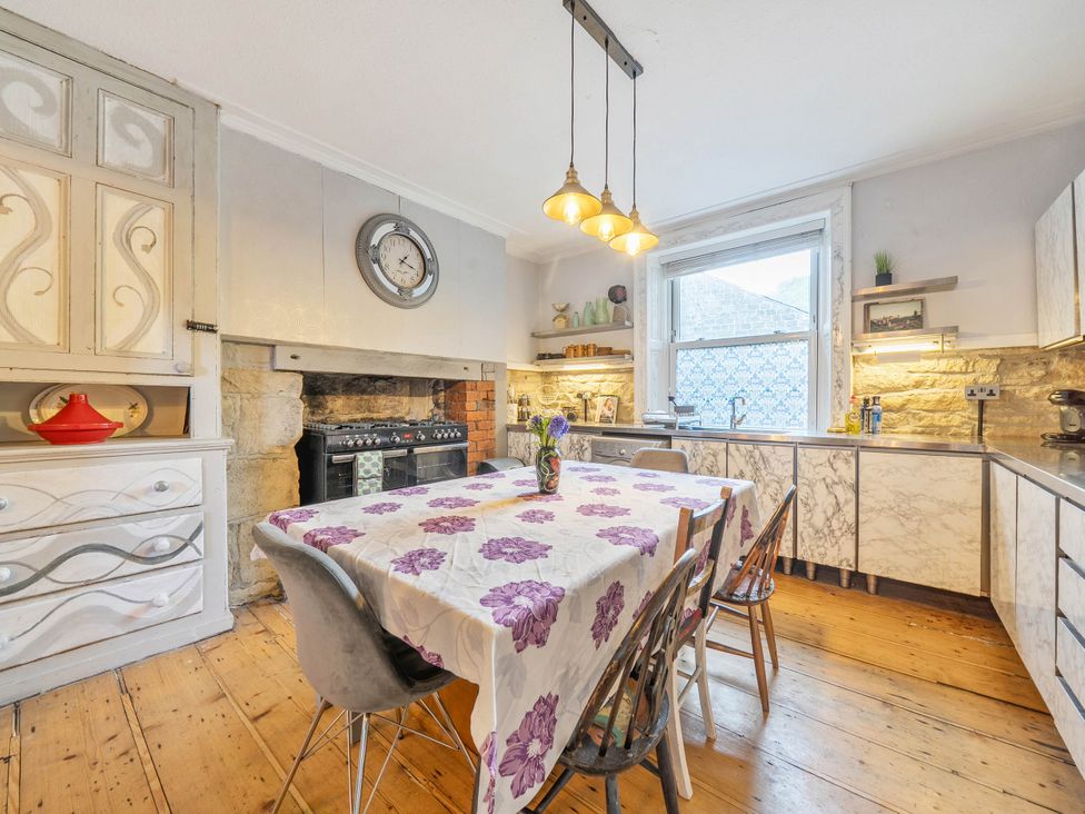 A kitchen with a table and stools at Hebden Bridge - House - Sleeps 8 - Pet Friendly in Hebden Bridge