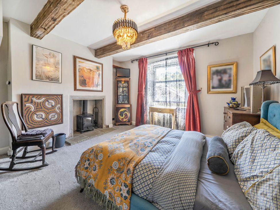 A bedroom with a bed, chair, window, and fireplace at Hebden Bridge - House - Sleeps 8 - Pet Friendly Hebden Bridge