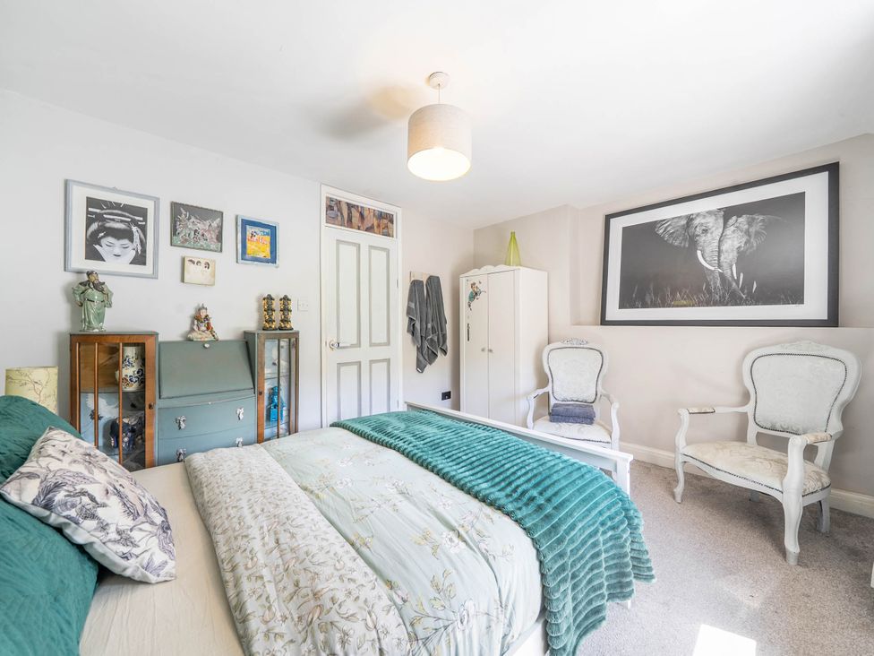 A bedroom with a bed and armchairs at Hebden Bridge - House - Sleeps 8 - Pet Friendly, Hebden Bridge