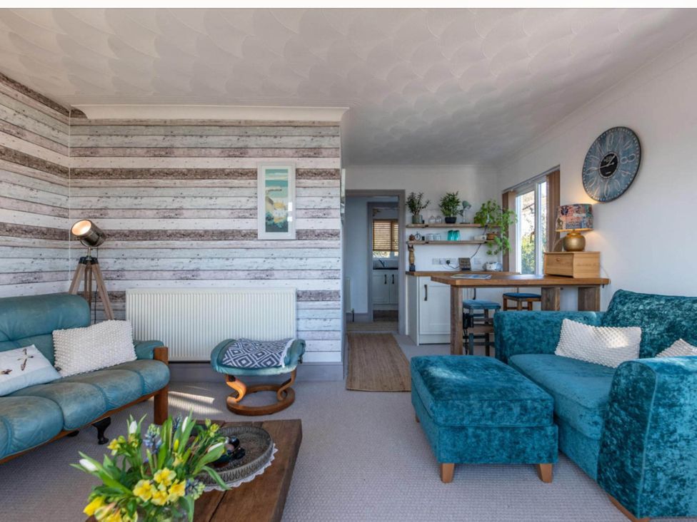 A living room with a sofa and dining area at 1 Bed Flat - Sleeps 2 - Pets - Balcony - Parking in Looe