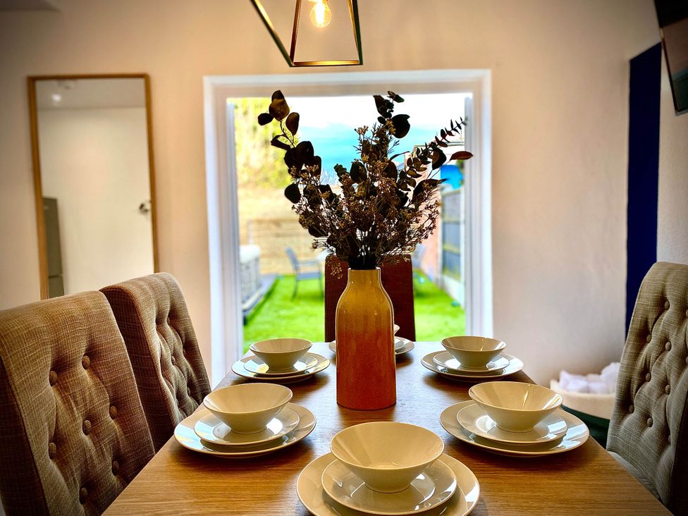 A dining room with a table set for meals at Family modern 3 bedroom hot tub house Blackpool