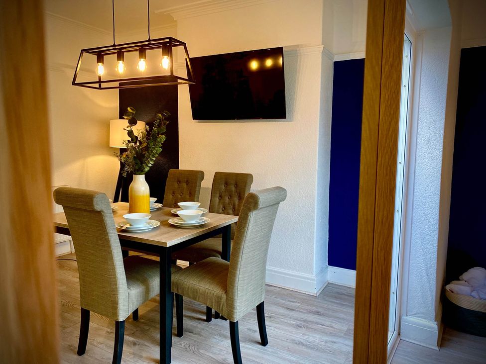 A dining room with a table and chairs at Family modern 3 bedroom hot tub house Blackpool