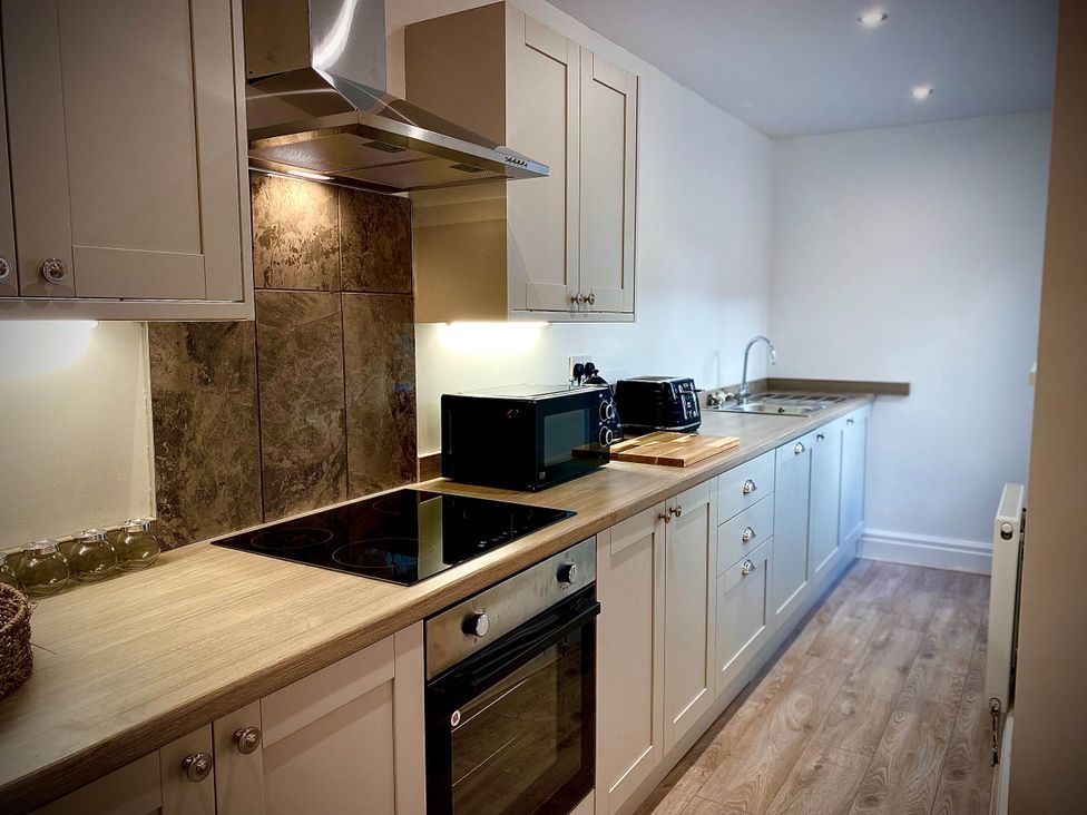 A kitchen with oven, stove, microwave, and sink at Family modern 3 bedroom hot tub house in Blackpool