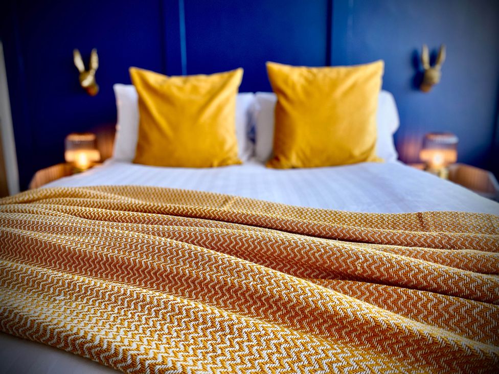 A bedroom with a bed and yellow pillows at Family modern 3 bedroom hot tub house Blackpool