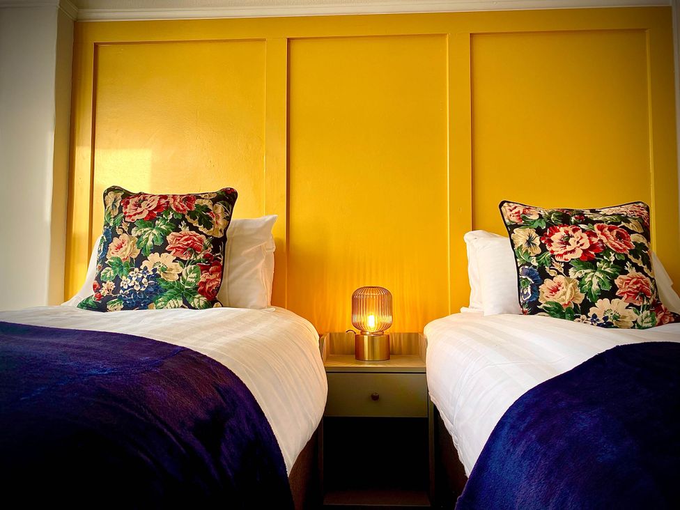 A bedroom with two beds and a lamp at Family modern 3 bedroom hot tub house in Blackpool