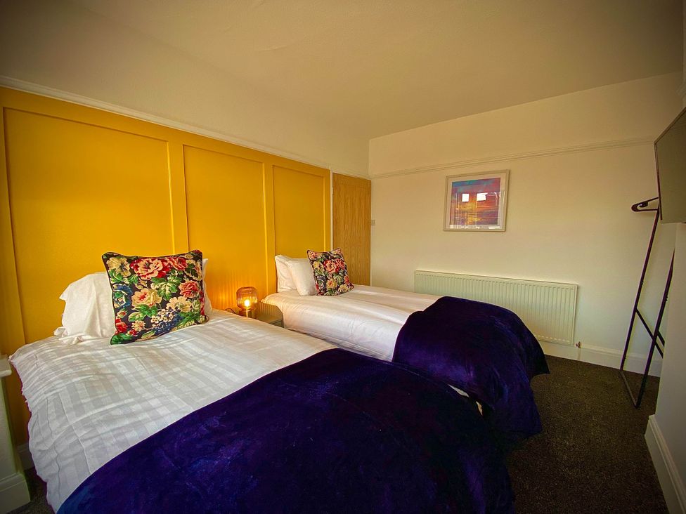 A bedroom with two beds and a door at Family modern 3 bedroom hot tub house Blackpool