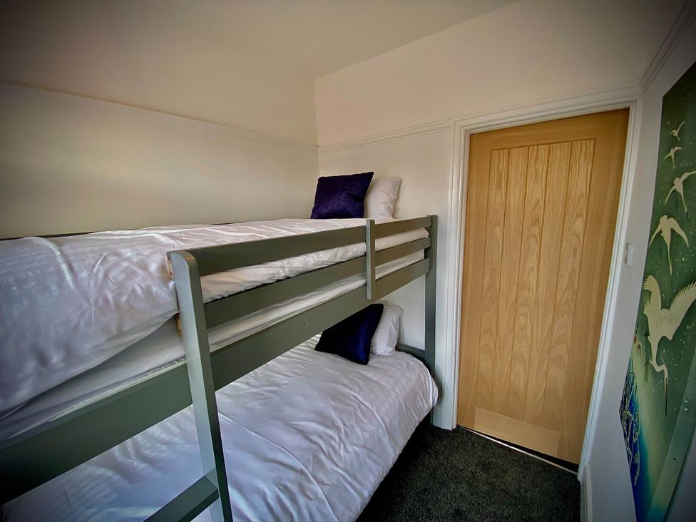 A bedroom with a bunk bed and a door at Family modern 3 bedroom hot tub house Blackpool