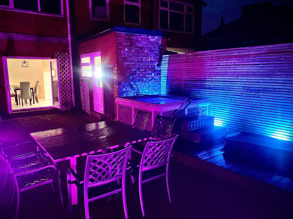 A garden with a hot tub and dining area at Family modern 3 bedroom hot tub house in Blackpool