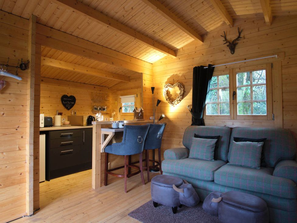 A living room with a kitchen area and seating at Cabin for 2 - Wood Burning Hot Tub & Fire, Larkhall