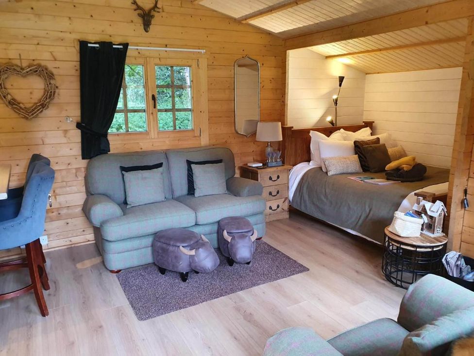 A living room with a sofa and bed at Cabin for 2 - Wood Burning Hot Tub & Fire in Larkhall