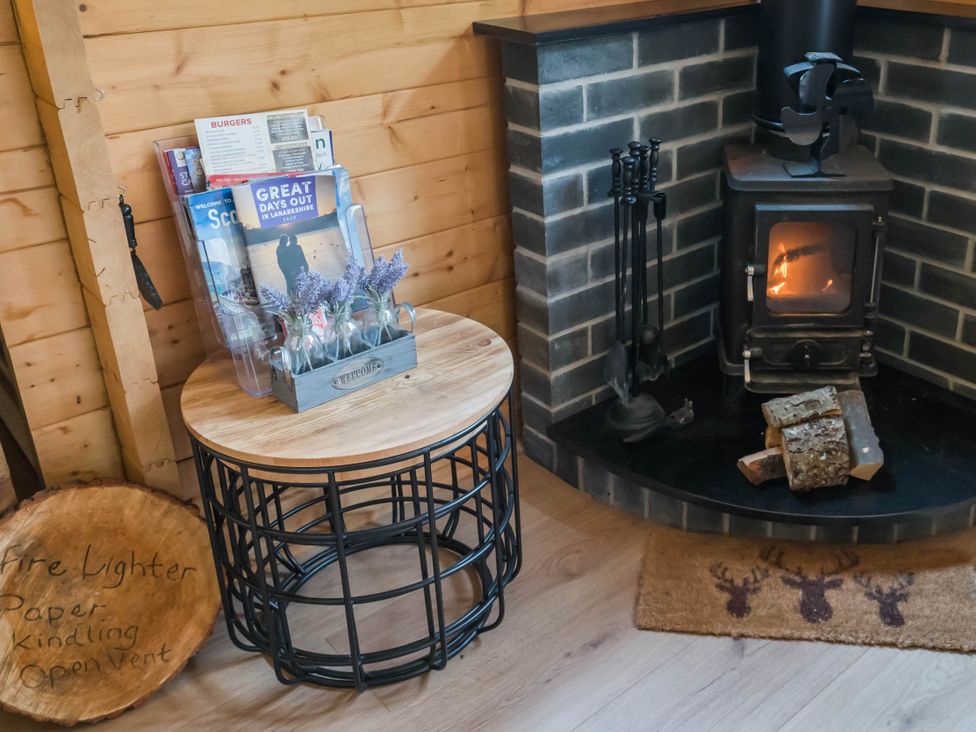 A living room with a wood stove and coffee table at Cabin for 2 - Wood Burning Hot Tub & Fire Larkhall