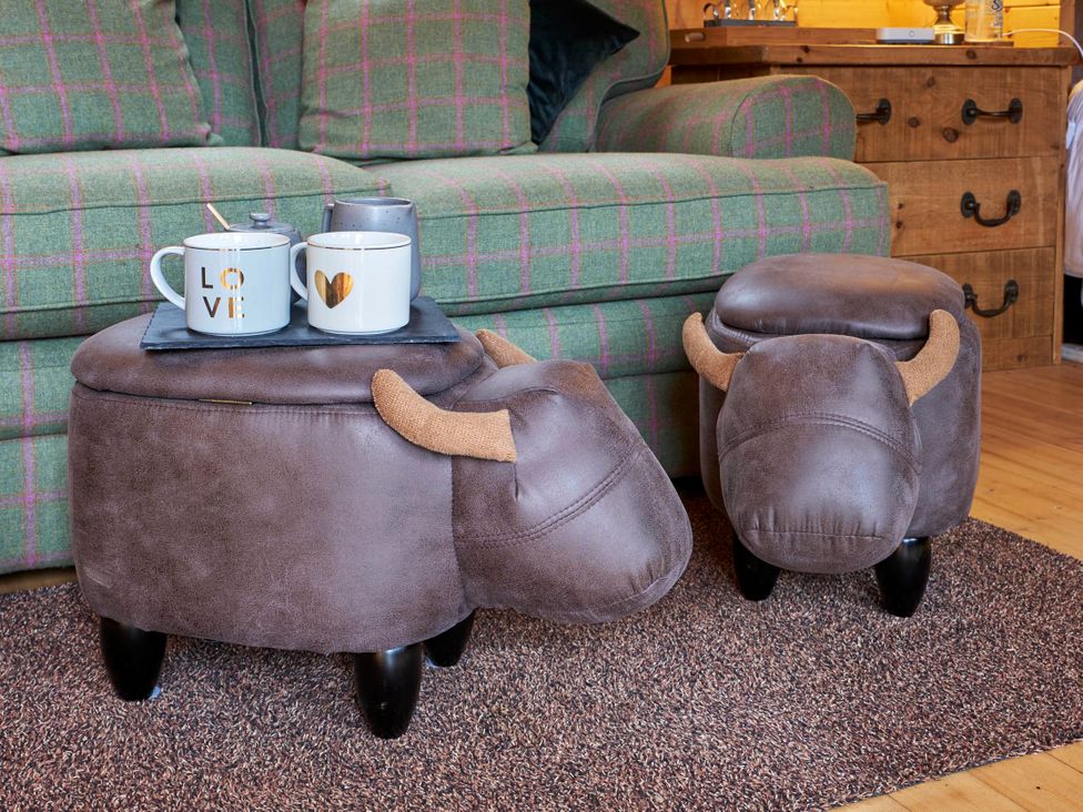 A living room with a sofa and decorative footstools at Cabin for 2 - Wood Burning Hot Tub & Fire, Larkhall