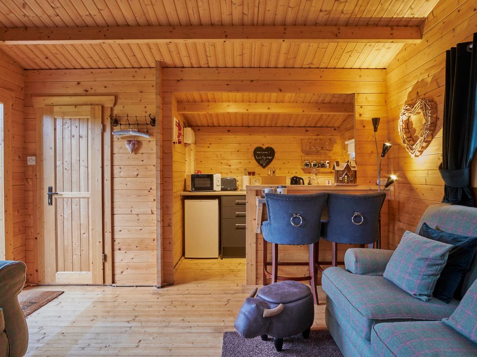A cabin with kitchen area and seating at Cabin for 2 - Wood Burning Hot Tub & Fire in Larkhall