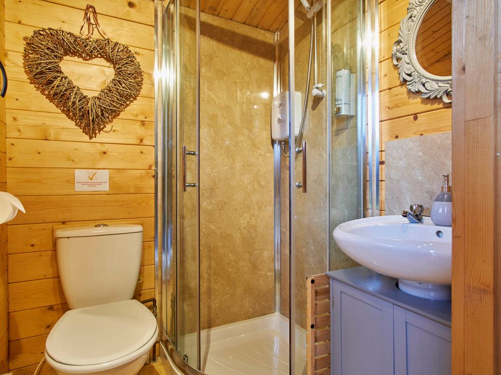 A bathroom with a toilet, shower, and sink at Cabin for 2 - Wood Burning Hot Tub & Fire in Larkhall