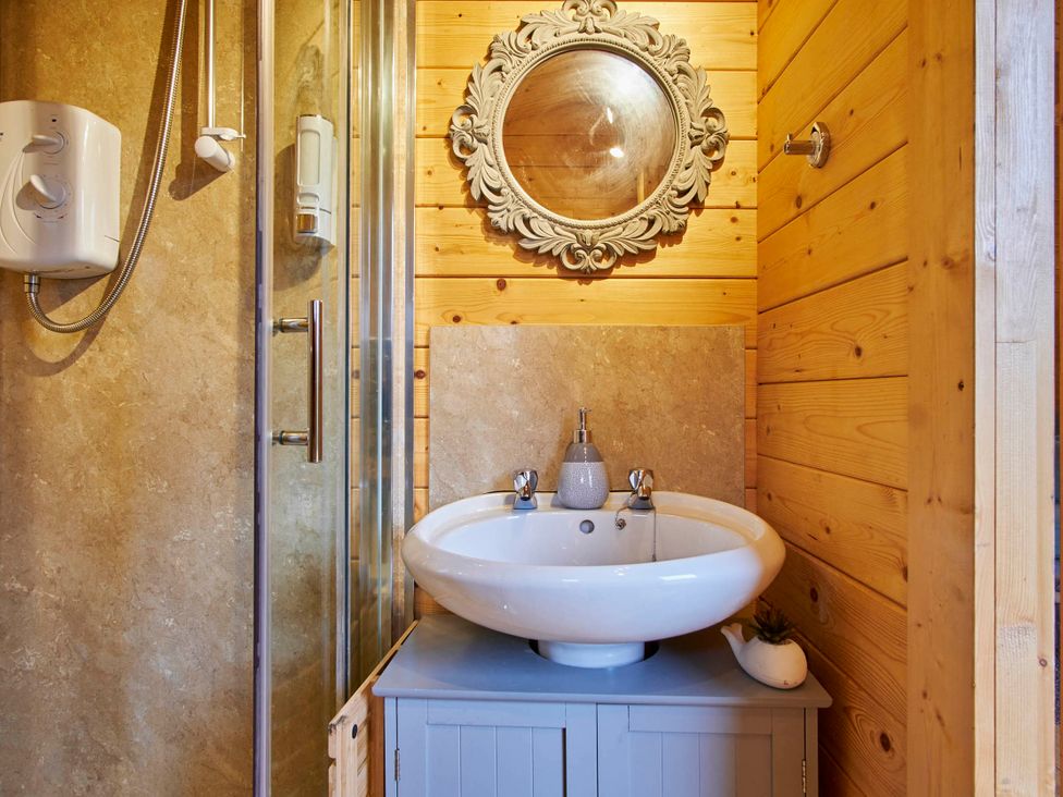 A bathroom featuring a sink, mirror, and a shower at Cabin for 2 - Wood Burning Hot Tub & Fire, Larkhall