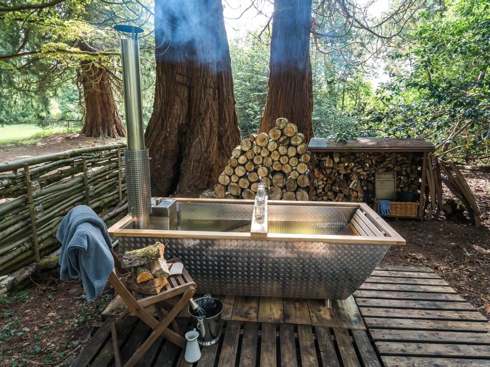 A hot tub with chimney and wooden surroundings at Cabin for 2 - Wood Burning Hot Tub & Fire, Larkhall