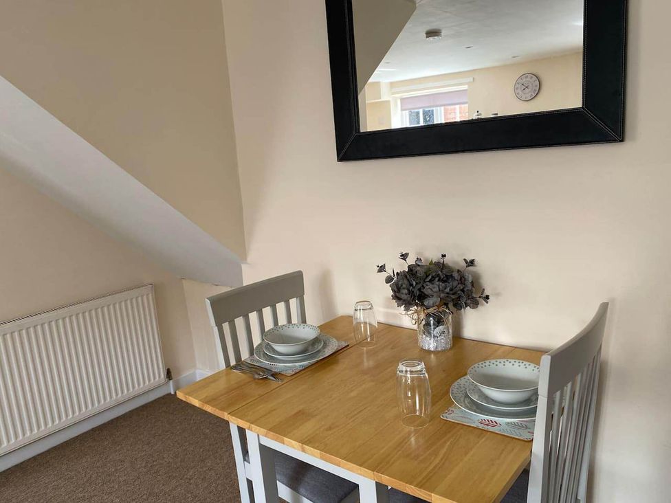 A dining table set with plates and glasses in the dining room at Apartment - Sleeps 2 - Pet friendly - Parking Ludlow