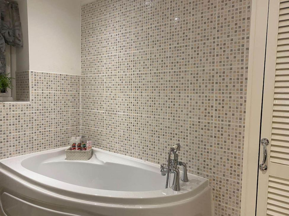 A bathroom with a bathtub and tiled wall at Apartment - Sleeps 2 - Pet friendly - Parking in Ludlow