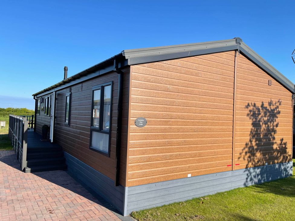An exterior view of a lodge with a deck area at Yorkshire View Lodge in Wilberfoss
