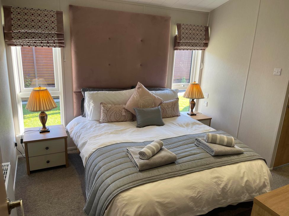 A bedroom with a double bed and bedside tables at Yorkshire View Lodge in Wilberfoss