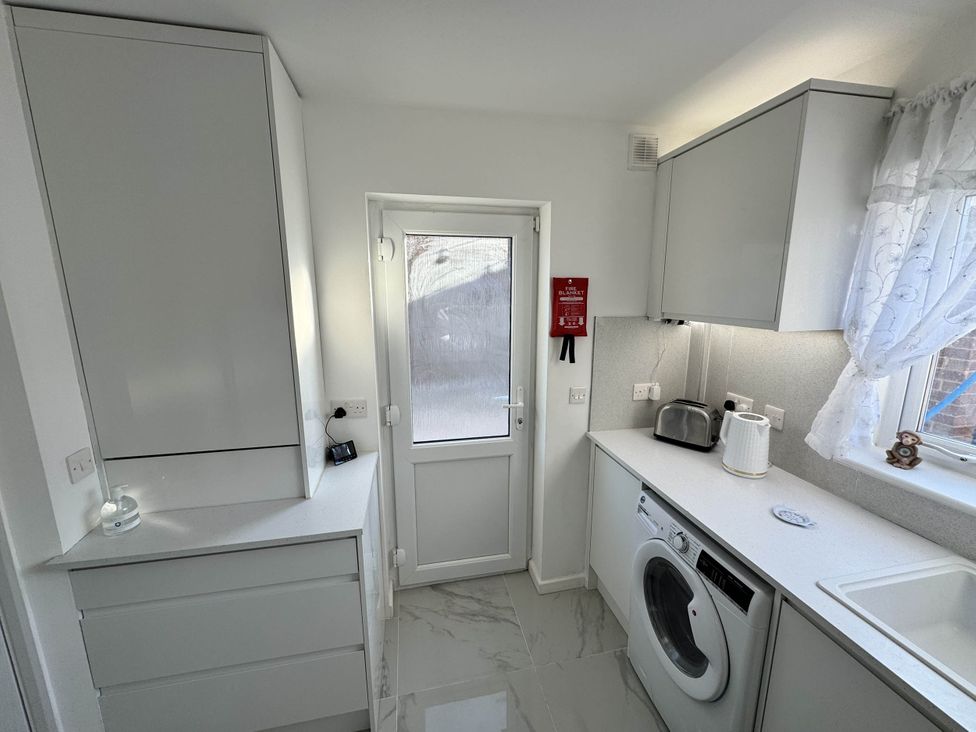 A kitchen with a washing machine and sink at Modern 3-Bed Hideaway Near Westgate With Parking, Canterbury