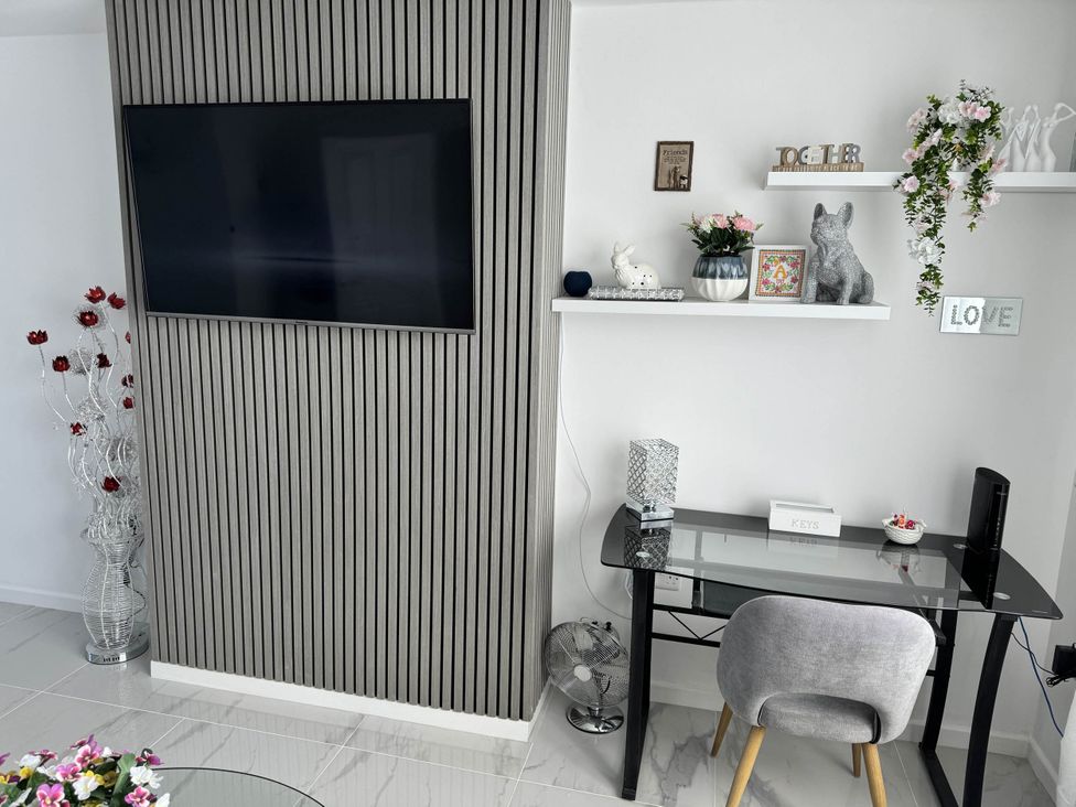 A living room with a television, desk, and decorative items at Modern 3-Bed Hideaway Near Westgate With Parking in Canterbury