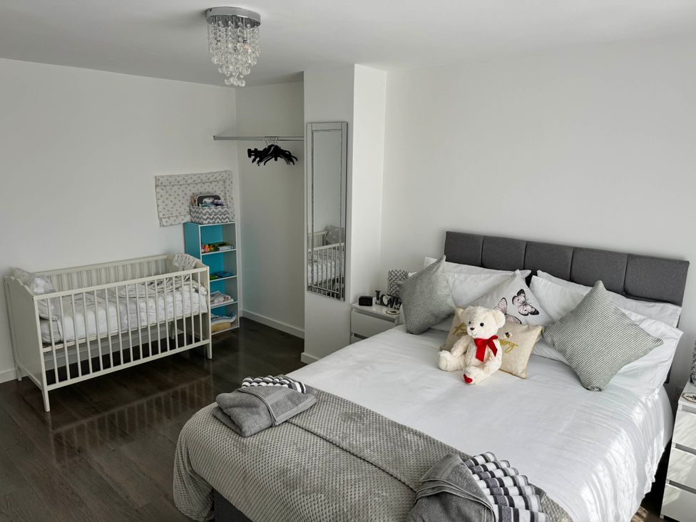 A bedroom with a crib and a bed at Modern 3-Bed Hideaway Near Westgate With Parking, Canterbury