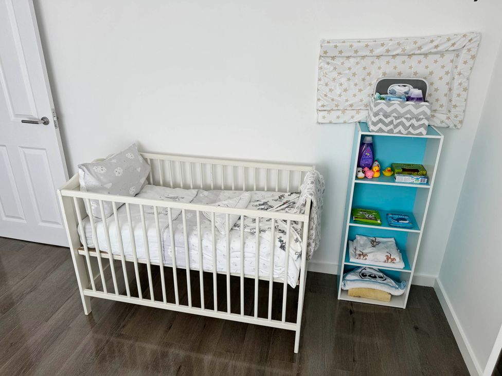 A nursery with a crib and shelving unit at Modern 3-Bed Hideaway Near Westgate With Parking, Canterbury