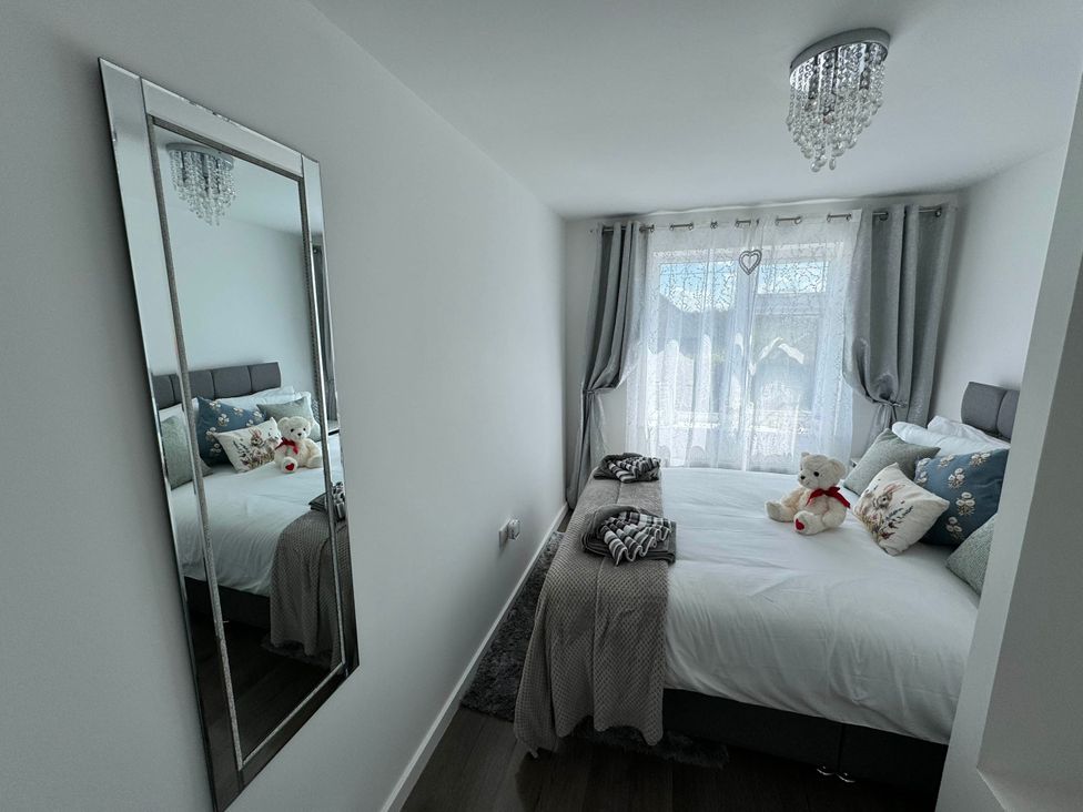 A bedroom with a bed and mirror at Modern 3-Bed Hideaway Near Westgate With Parking, Canterbury