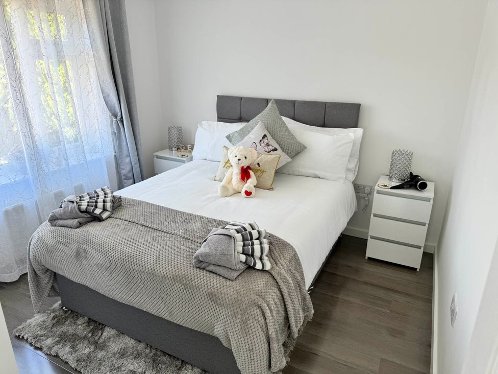 A bedroom with a bed and nightstand at Modern 3-Bed Hideaway Near Westgate With Parking in Canterbury