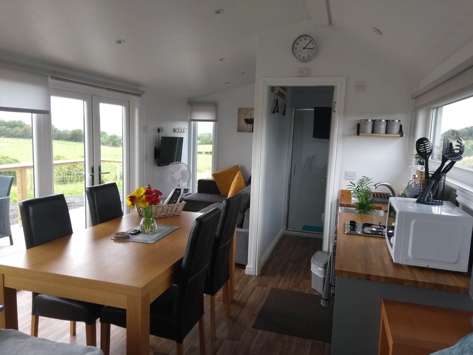 A living room with a dining table and sofa at Cleeves Cabins 1, Ailsa Luxury Lodge with hot tub, St. John's Town Of Dalry