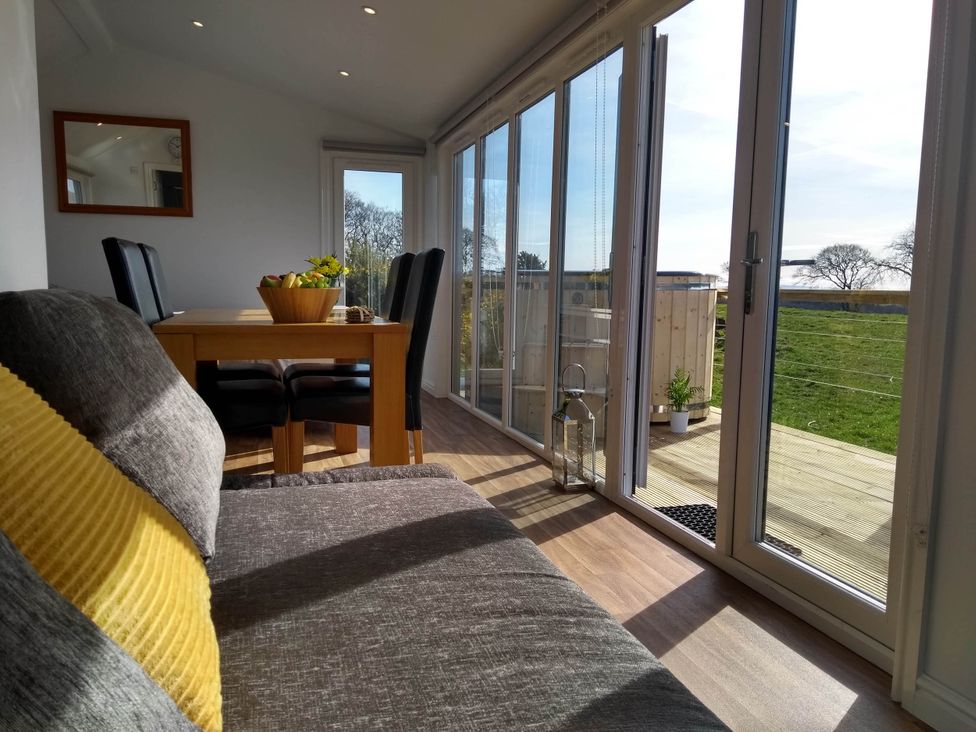 A dining room with a table and chairs at Cleeves Cabins 1, Ailsa Luxury Lodge with hot tub, St. John's Town Of Dalry