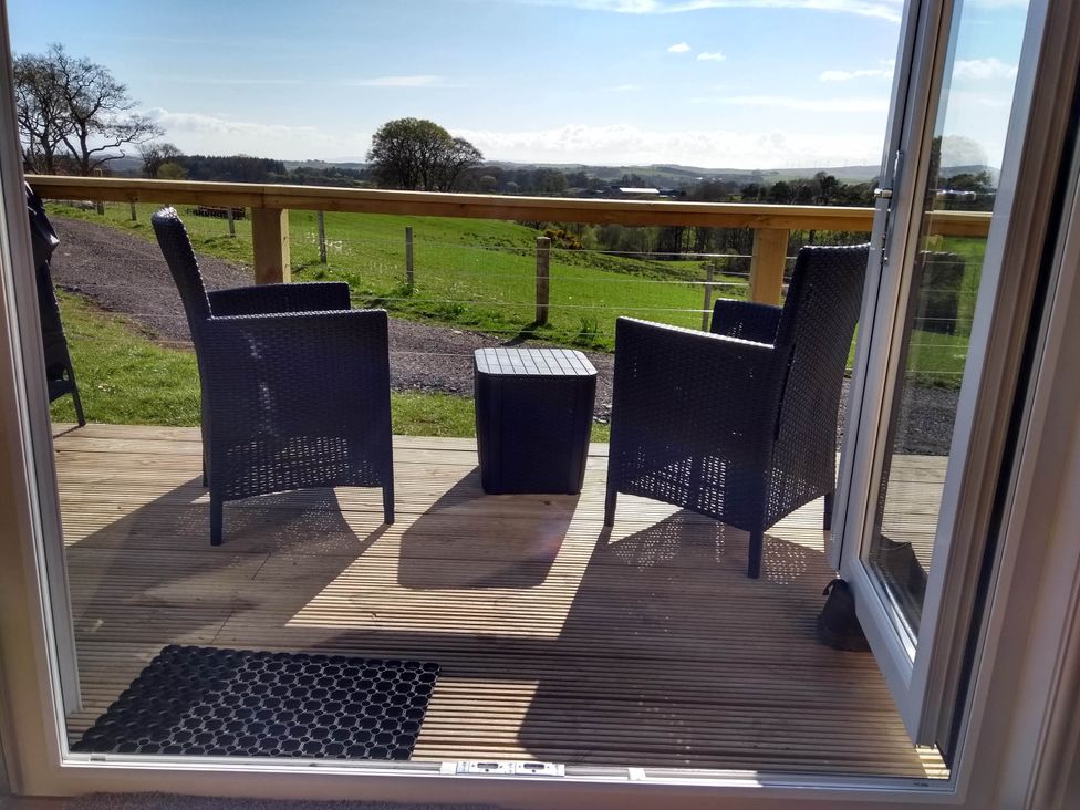 A deck area with two chairs and a table at Cleeves Cabins 1, Ailsa Luxury Lodge with hot tub, St. John's Town Of Dalry