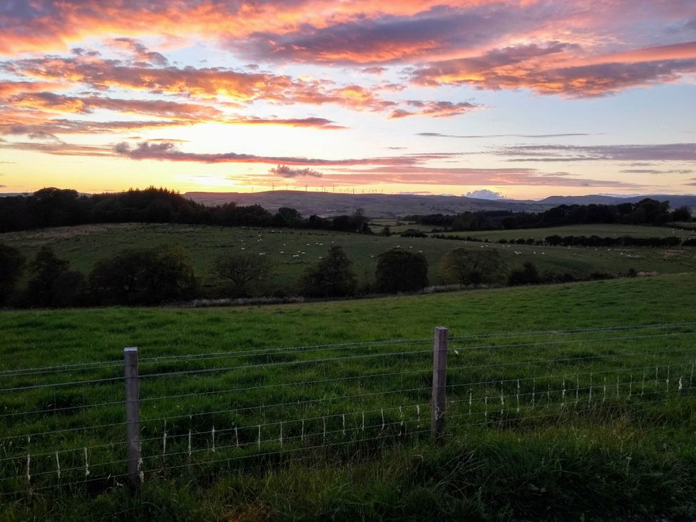A view of a field at sunset with a fence at Cleeves Cabins 1, Ailsa Luxury Lodge with hot tub St. John's Town Of Dalry