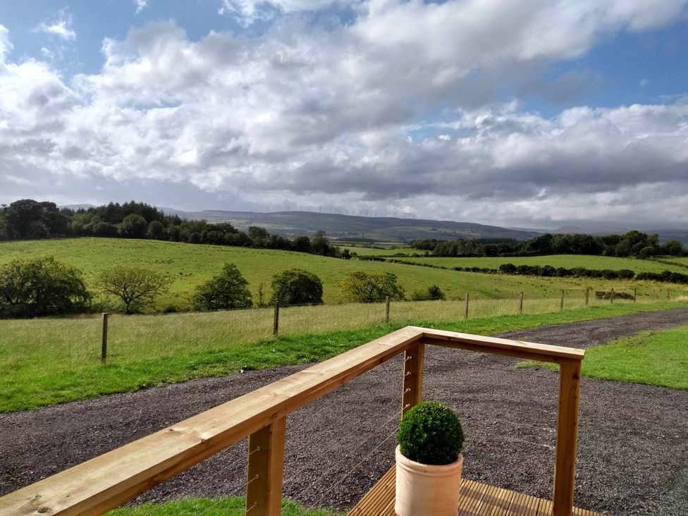 A view of a green landscape with a railing and plant at Cleeves Cabins 1, Ailsa Luxury Lodge with hot tub, St. John's Town Of Dalry