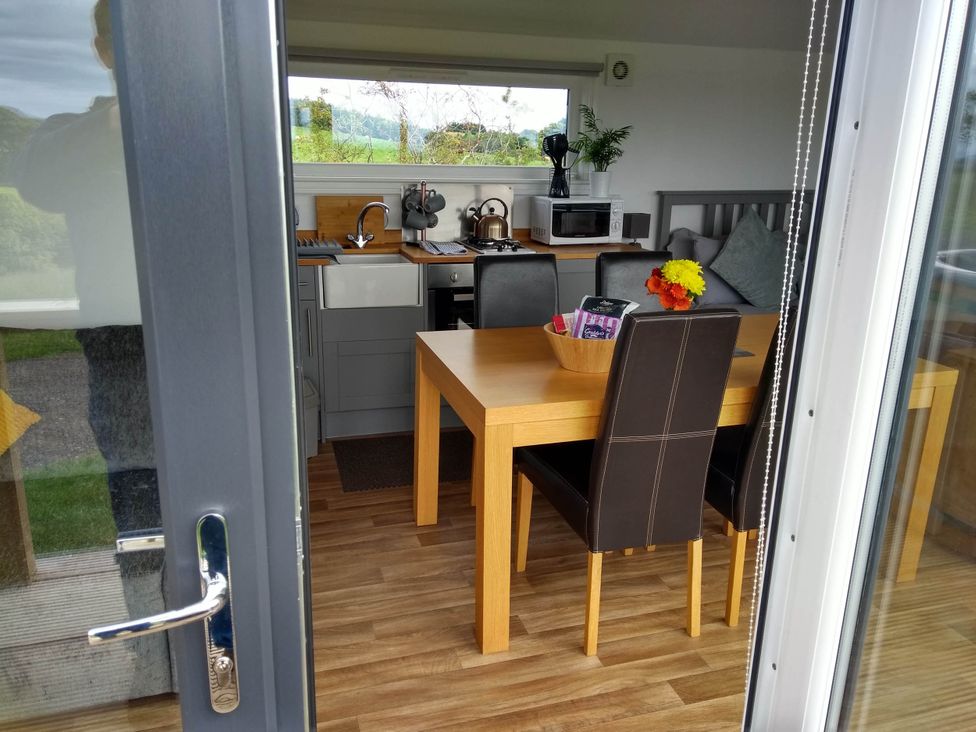 A kitchen with a table and chairs at Cleeves Cabins 2, Arran Luxury Lodge with hot tub St. John's Town Of Dalry