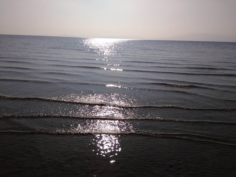 A view of the sea with sunlight reflecting on the water surface