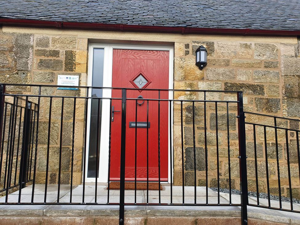 A front entrance with a red door and railing at 2-Bed Barn, Hot Tub & Pet Friendly near Muirkirk