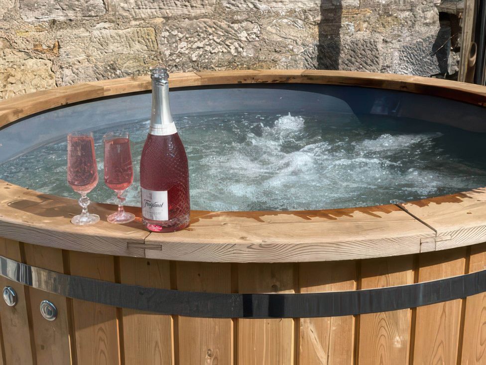 A hot tub with sparkling wine and glasses at 2-Bed Barn, Hot Tub & Pet Friendly near Muirkirk