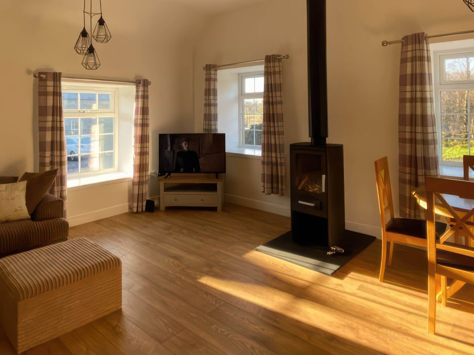 A living room with a sofa, television and dining table at 2-Bed Barn, Hot Tub & Pet Friendly near Muirkirk