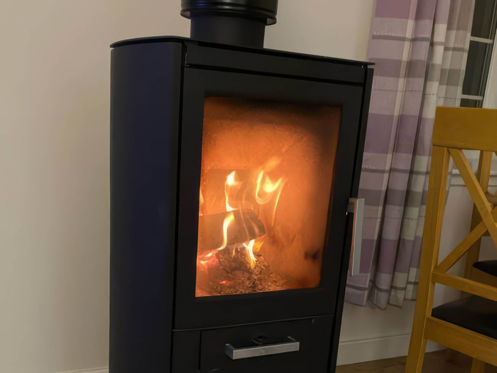 A stove with fire in a living room at 2-Bed Barn, Hot Tub & Pet Friendly near Muirkirk