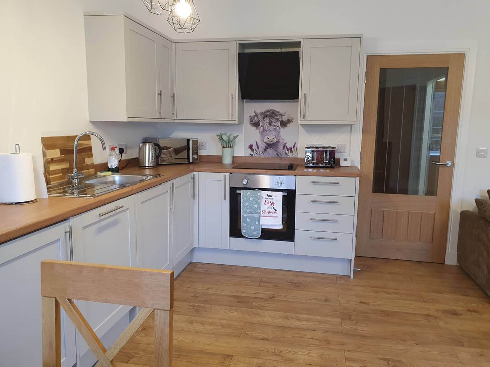 A kitchen with a sink, kettle, oven, and microwave at 2-Bed Barn, Hot Tub & Pet Friendly near Muirkirk